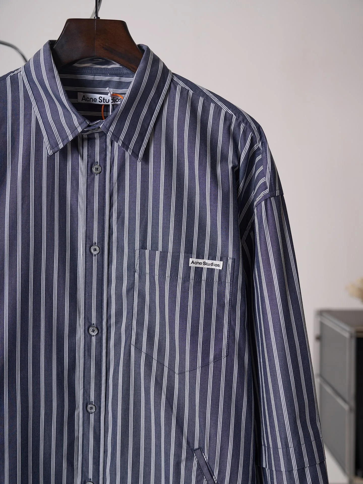 [Real auction] Acne Studios logo double-sleeved striped long-sleeved shirt [In Stock] 44 46 48 50 Customized matte woven combed poplin, crisp and stylish, comfortable and close to the skin, misty charcoal blue interwoven with pure white vertical stripes, between the rising and falling lines, revealing the cool and relaxed style of Scandinavia. Cleverly created layered double-sleeved deconstructed tailoring, breaking the inherent paradigm of traditional shirts, giving the body staggered three-dimensional layers. The iconic stripes of the season are laid out vertically. Rhythm runs through the entire garment. The left chest pocket is embellished with the Acne Studios logo. The brand context is engraved in the square dimensions. The side seams are equipped with wide welt pockets. Integrating styling aesthetics and practical functions. Adhering to the high-end aesthetics of minimalism. Pioneer ingenuity returns to daily life. It interprets the Nordic ready-to-wear attitude of symbiosis of relaxation and sophistication. Infrared positioning cutting machine uses infrared emitters and infrared receivers to achieve precise positioning of materials. The accuracy can reach the micron level. So as to meet the effect of high-precision cutting of plaid alignment. Manual infrared line drawing pockets are assisted by infrared technology to achieve precise positioning and marking of pocket positions, which retains the fineness and flexibility of hand sewing. It adopts side-turning embedded stitching technology to provide high-quality stitching results. Smooth and tidy. The fabrics have been sand washed and have a better hand feel. Not easy to deform, not easy to shrink, not easy to fade, and maintain long-term beauty and loose fit.